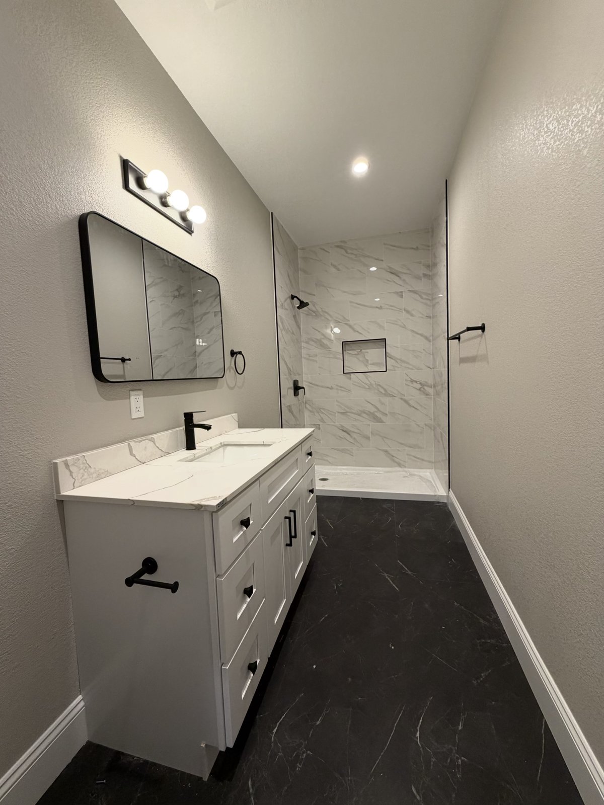 Renovated bathroom with walk-in marble shower at Concord Estate